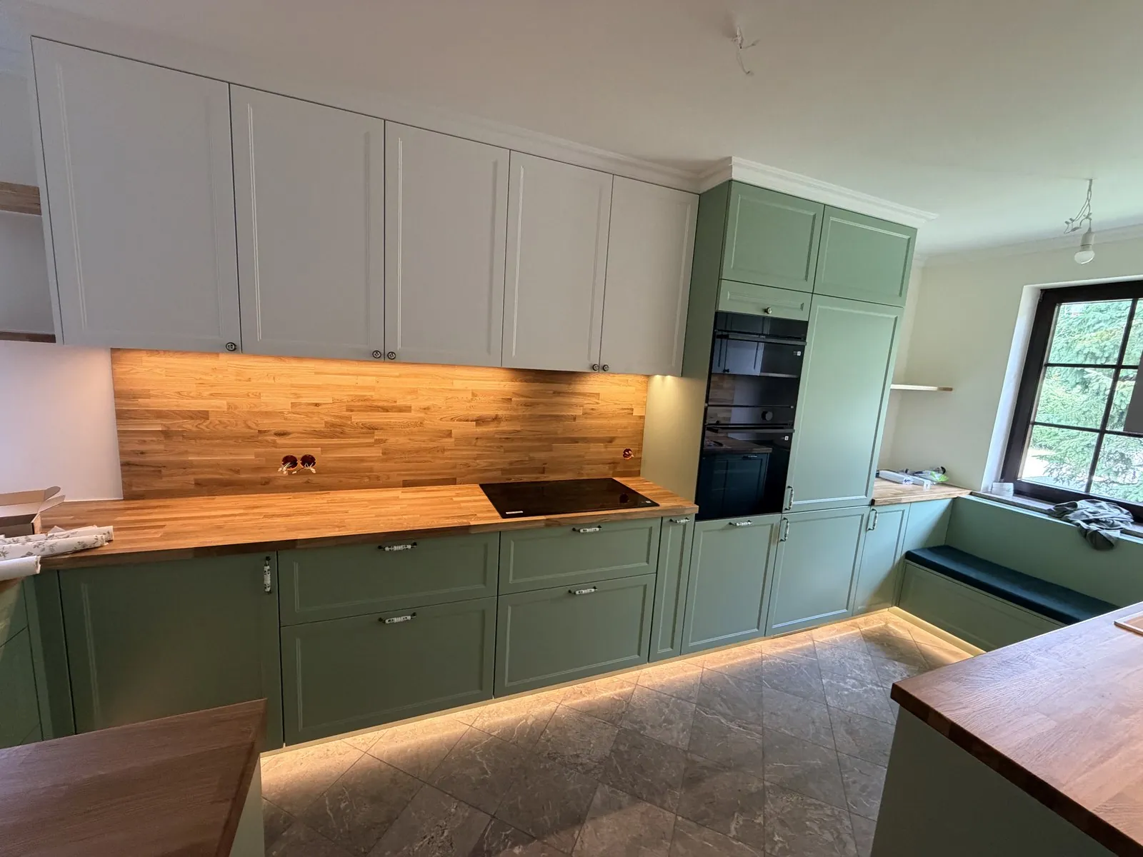 Green shaker kitchen with a bench